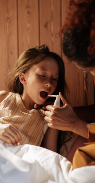 Bambina assume spray per la gola
