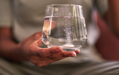 Close up del bicchiere d'acqua con una compressa effervescente
