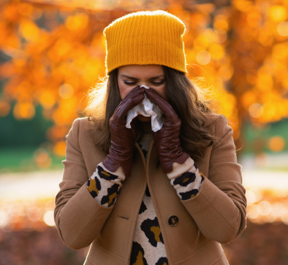 Donna al parco che soffia il naso