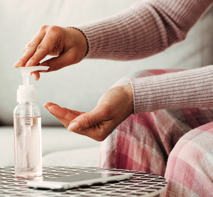 Mani femminili che utilizzano il disinfettante